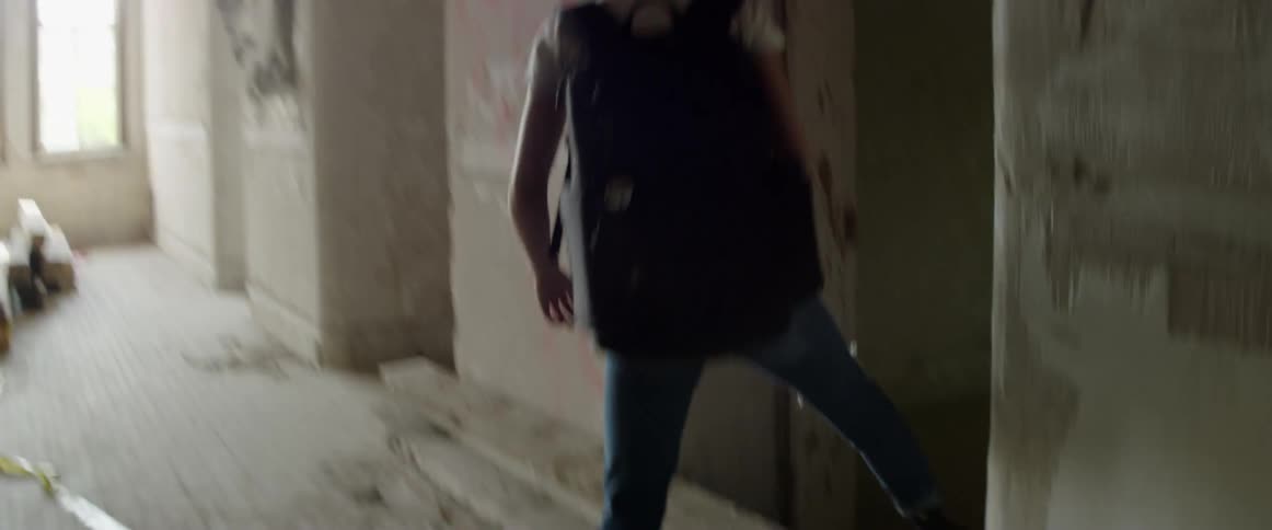 A teenager steps through a doorway in a building