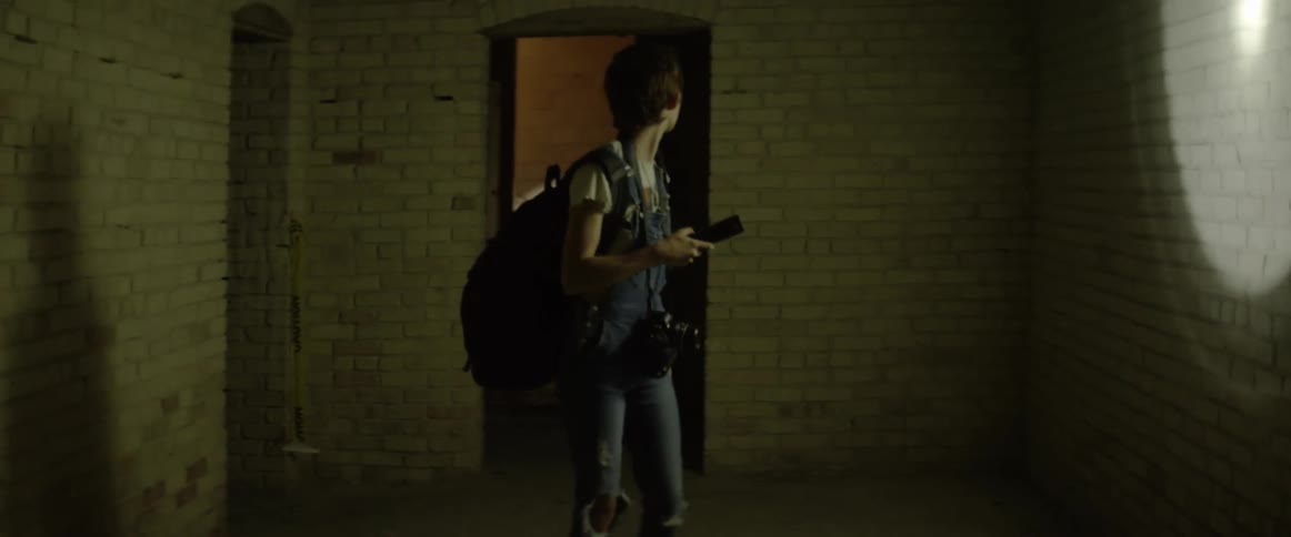 A teenager with a flashlight enters a room and then is chased by a man