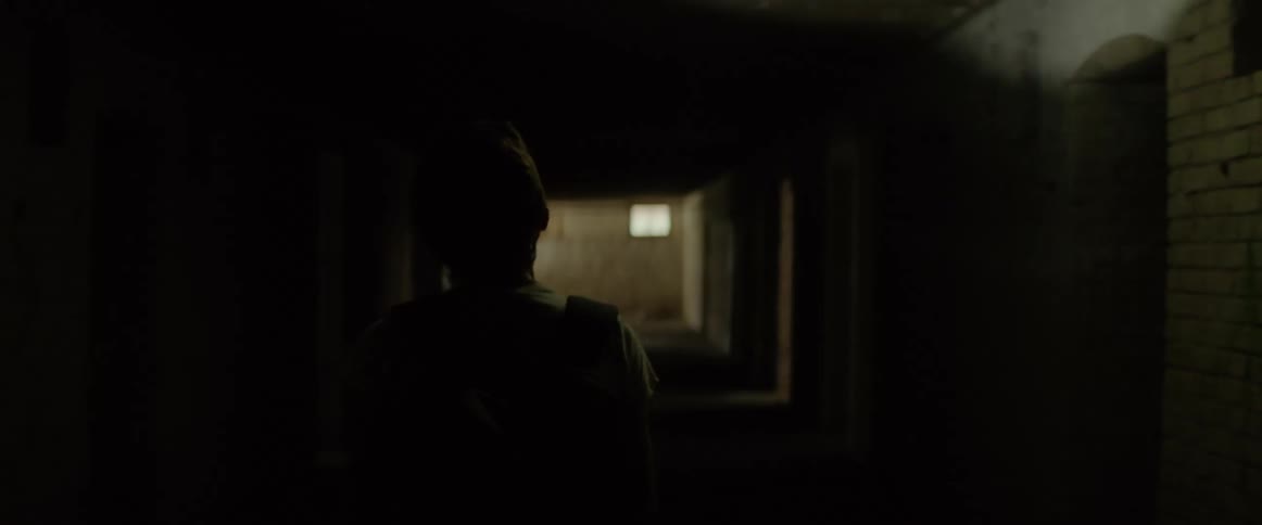 A white woman with a flashlight gets spooked and runs while exploring a decrepit building