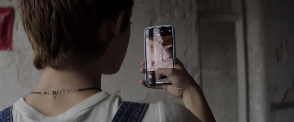 A woman is holding a cell phone and taking pictures