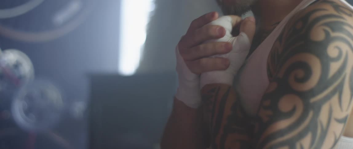 A man rubs and clenches his wrapped up hand