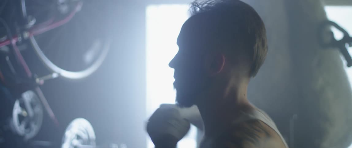 Male fighter does shadow boxing in the garage