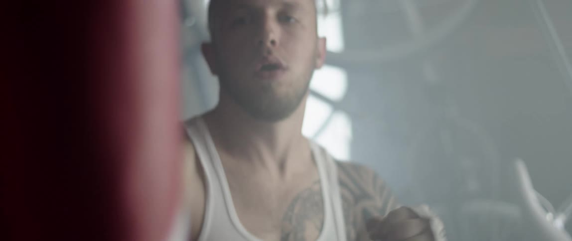 A man is boxing a punching bag indoors