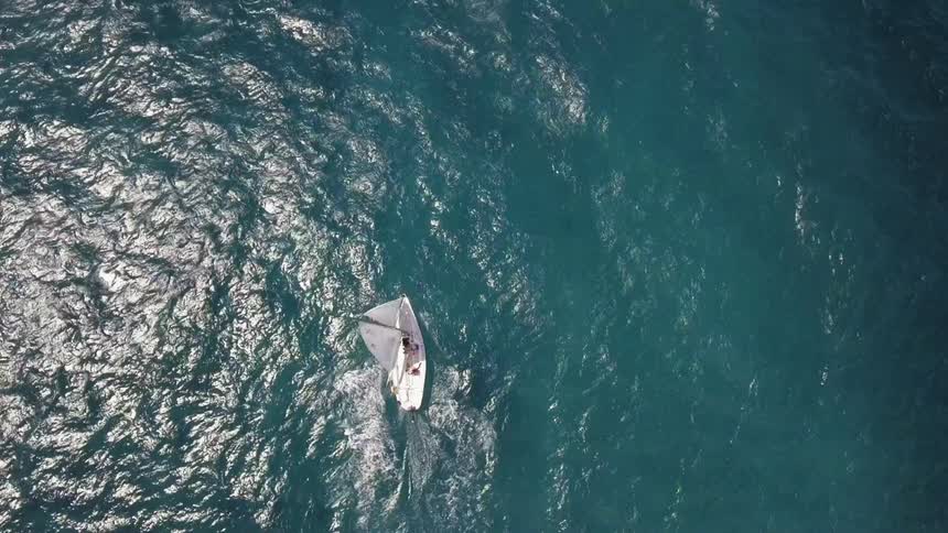 A sailboat sailing in the middle of the ocean