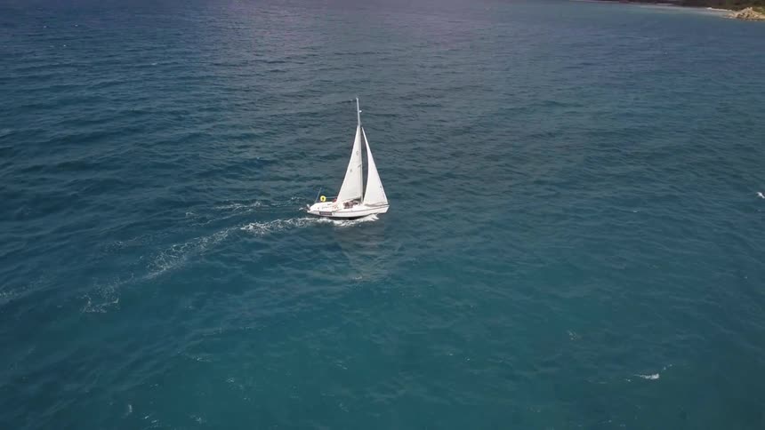 A sailboat on the ocean near the coast