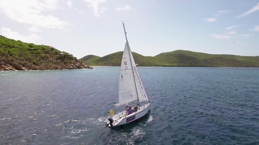 A sailboat glides over water on a lake on a sunny summer day