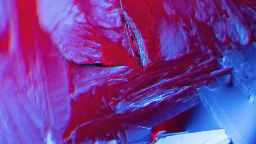 Abstract crystals grow under a microscope using polarising filter