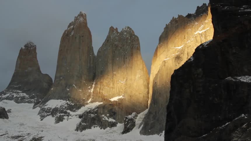 Tall rocks sit on the side of a snow covered trail