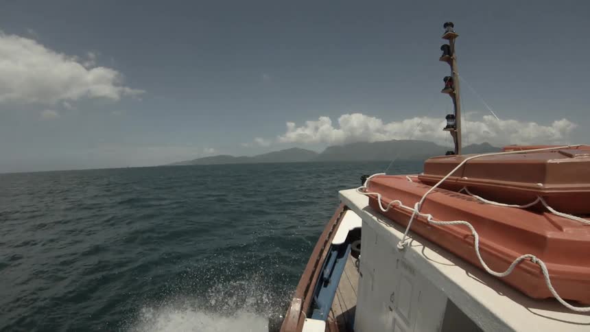 The side of a boat is shown as it skims across the water