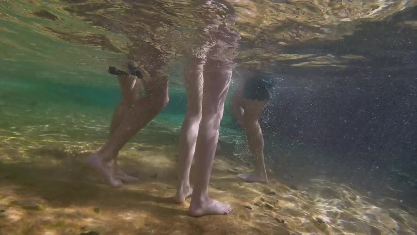 Underwater view of children standing in the ocean