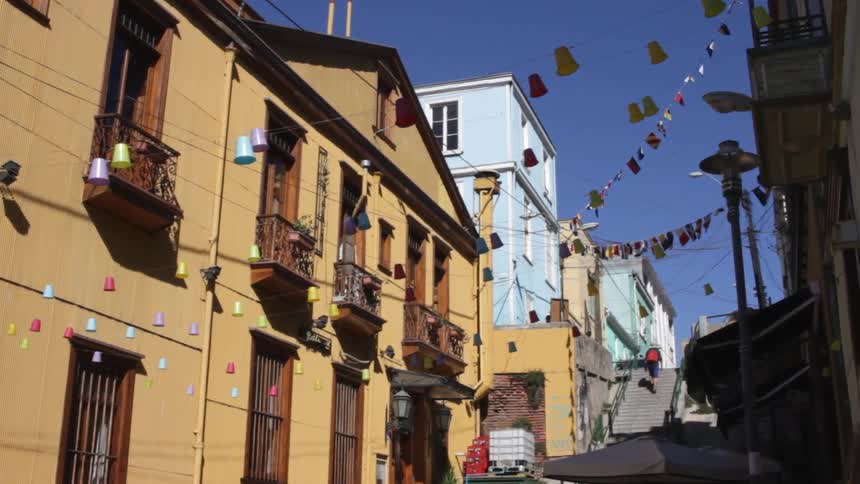 A row of houses go uphill as a man climbs the steps ahead