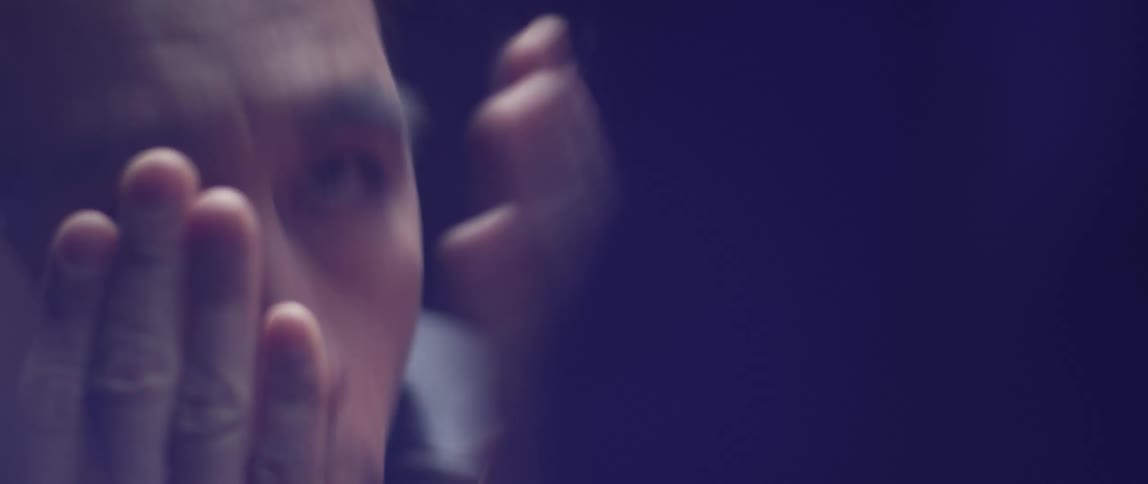 A man playing peekaboo through a glass