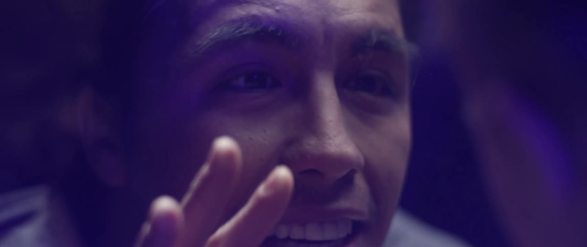 A man puts his hand on glass and talks to someone else through it