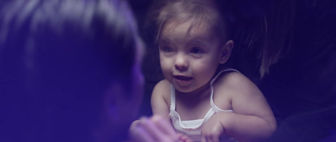 A woman holds a child and her father talks to her