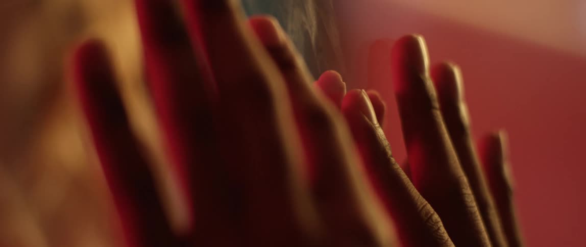 Two people attempt to touch hands but are blocked by a transparent barrier