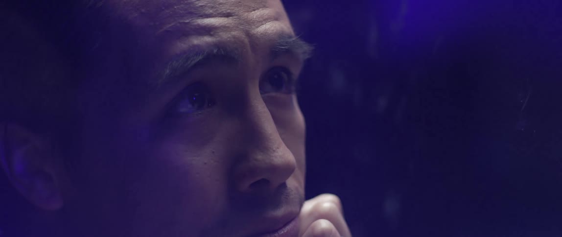 A man rests his chin in his hand and he talks to someone