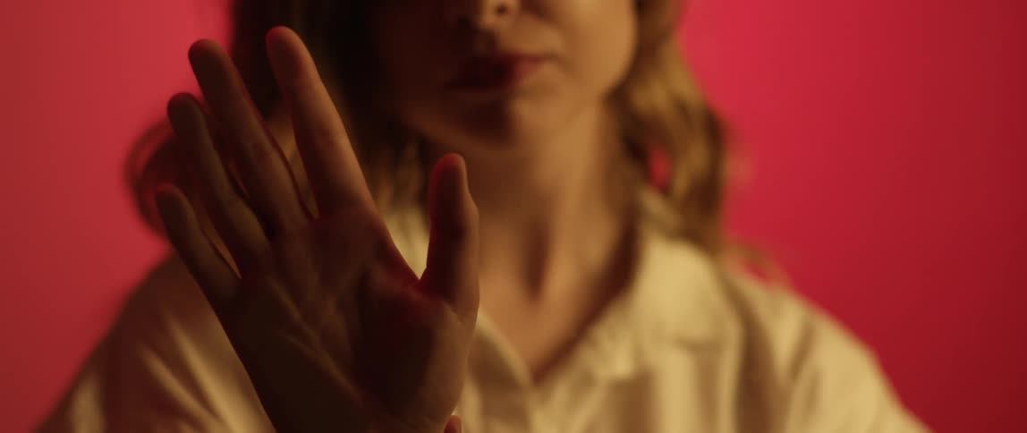 A white woman gazes longingly as she strokes a hand