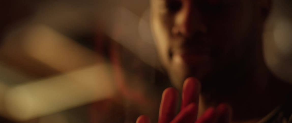 A man looks down at his and her hands pressed to the glass barrier between him and his wife