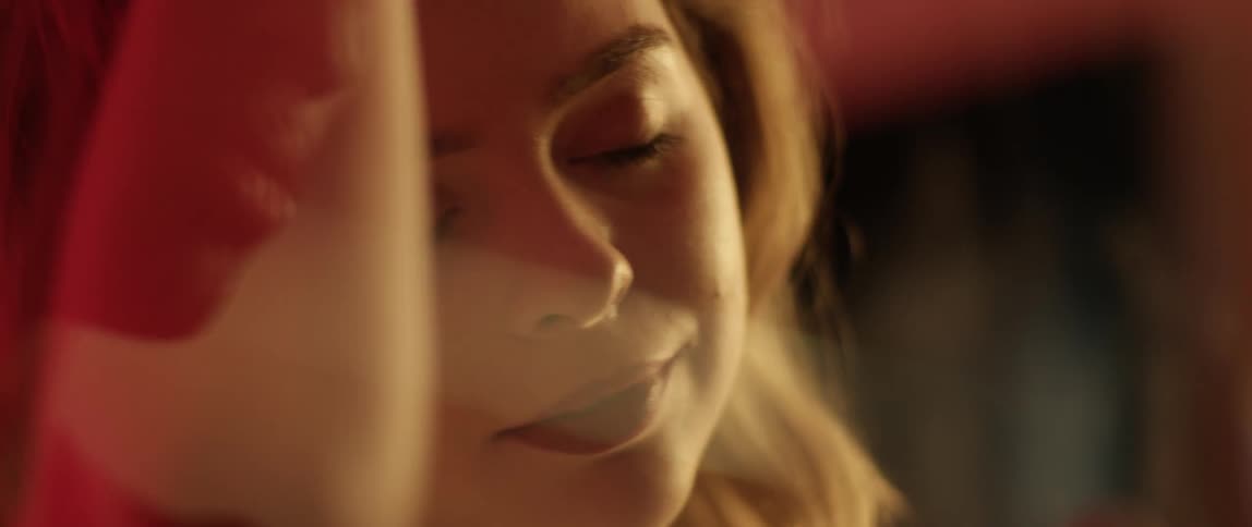 A woman talks to a man through glass