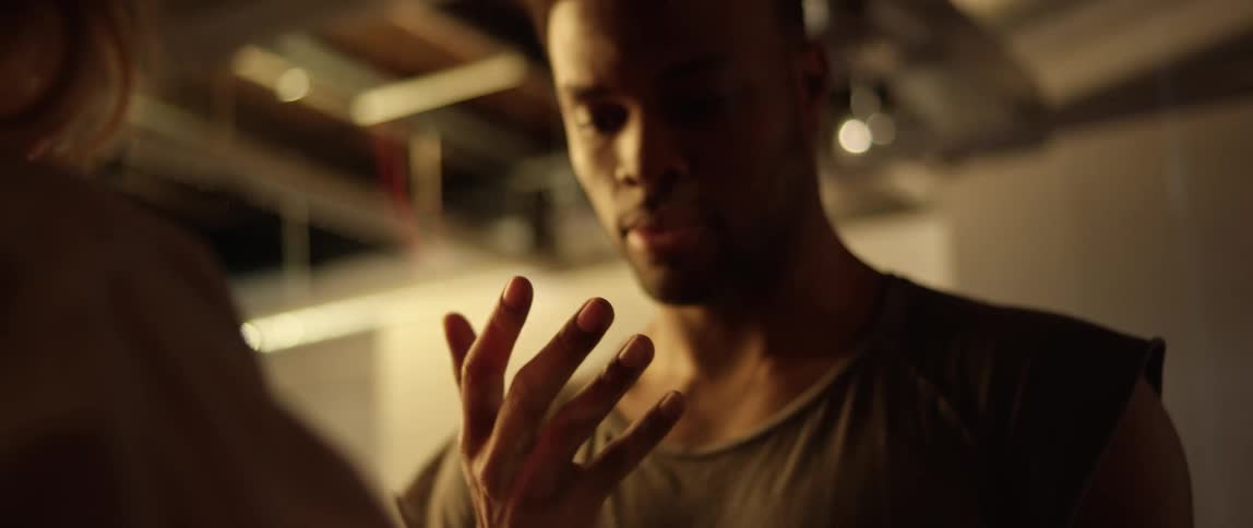 A black man examines his hand and looks at a woman in a questioning manner