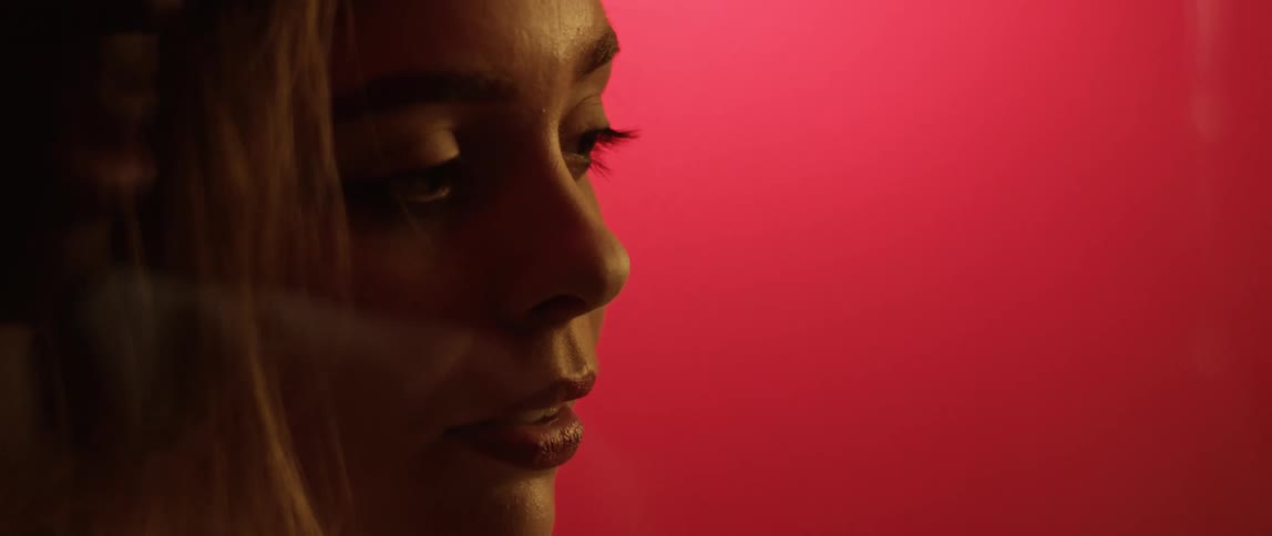A woman looking through a glass with a reflection of another person