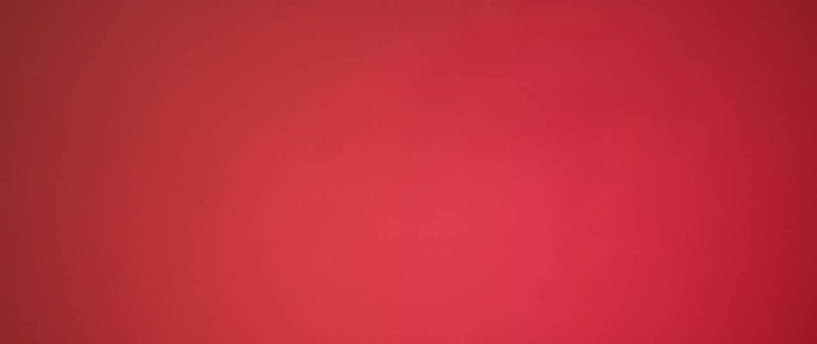 A vertical line shadow moves across a red wall