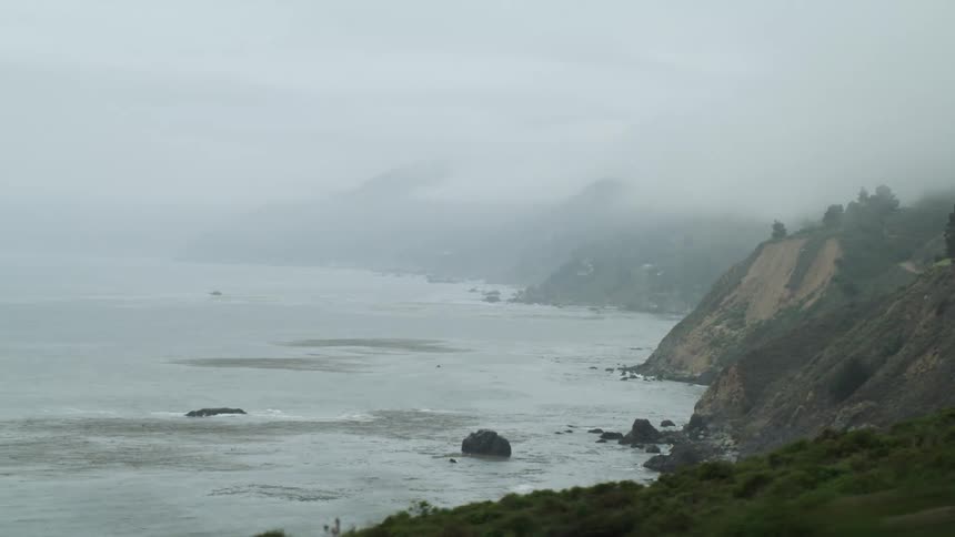 Driving alongside the coast on a foggy morning