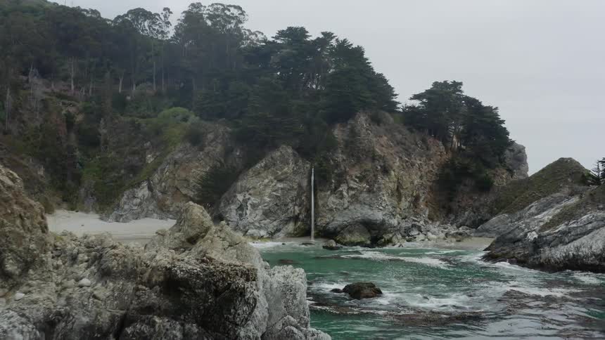 Aerial view of big rocks and cliffs next to the ocean on a cloudy day