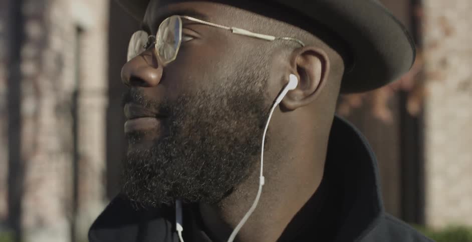 A man wearing glasses looks up and walks away