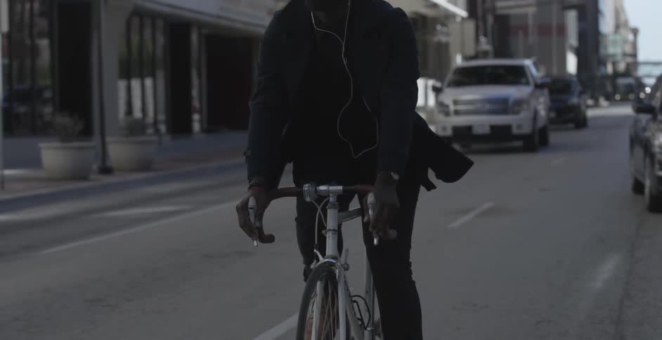 A man riding a bicycle in traffic on a city street