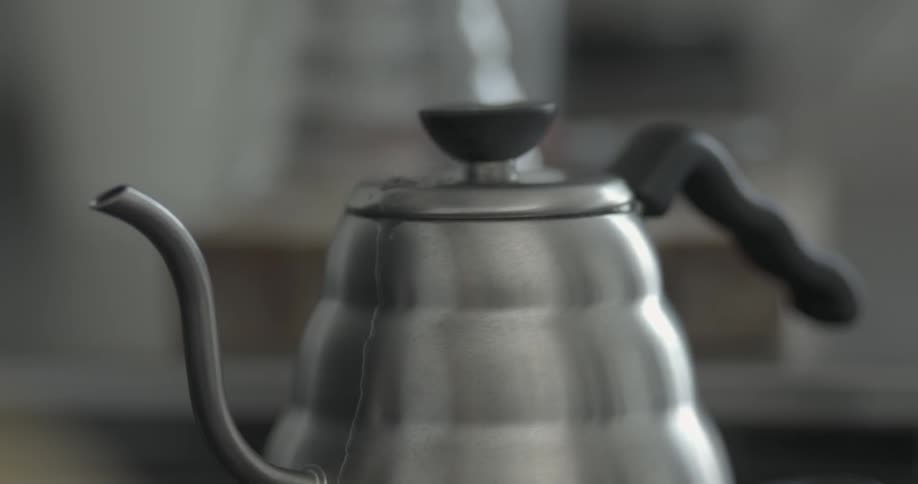 A coffee pot is boiling water as steam rises