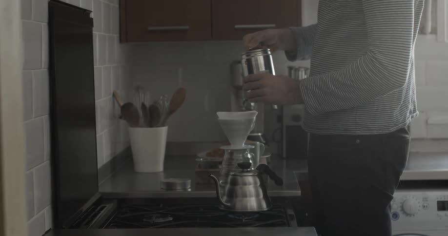 A man is pouring coffee into a cylinder