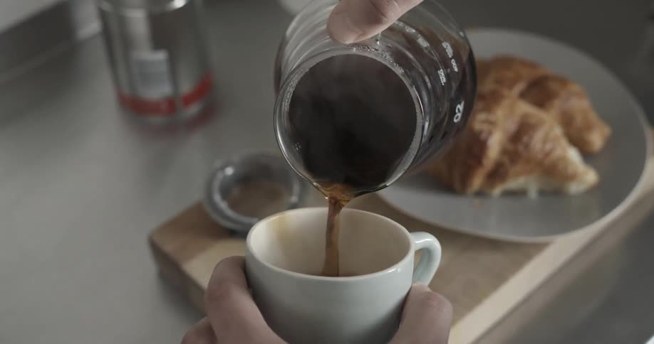 A man pours a cup of hot coffee