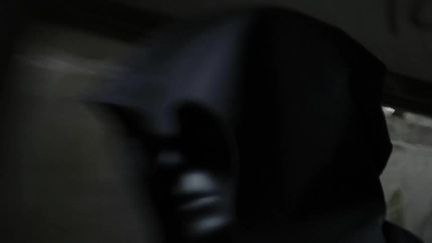 A man wearing a cloak slowly raises his head