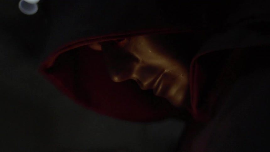 Mysterious person wearing golden mask and robe in candlelight