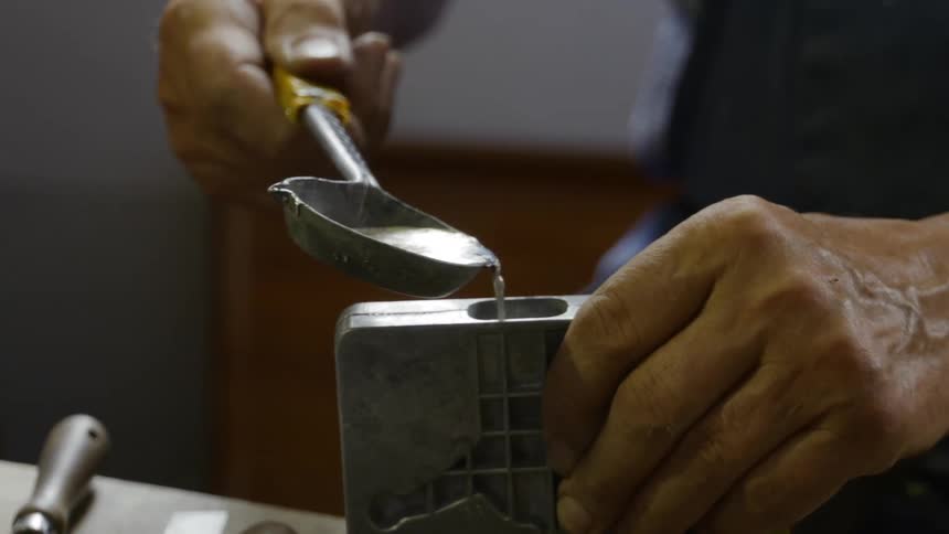 A man pours liquid in to a metal container