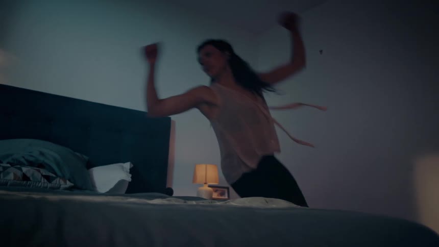 A teenager dances in her room and throws herself on her bed