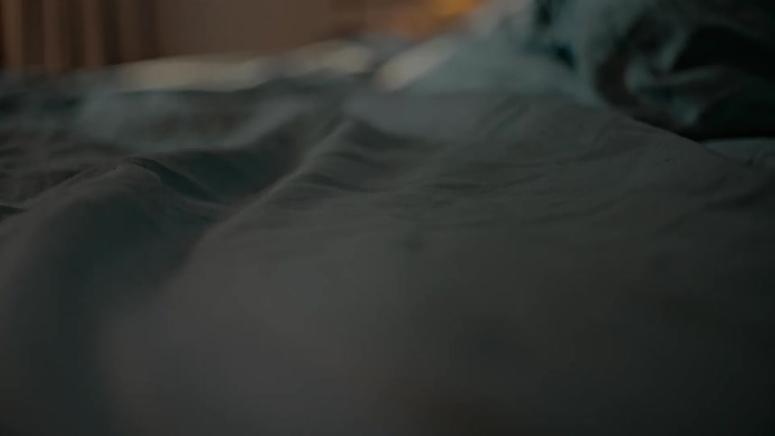 Light shines across a sheet on a bed