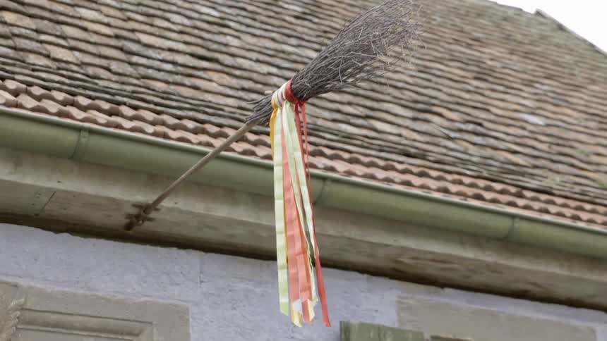 Multicolored ribbon hangs from a stick attached to a roof