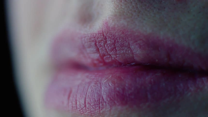 A woman wearing pink lipstick smiles