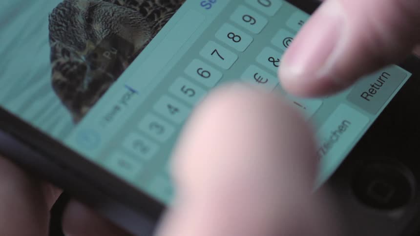 Person types on keyboard on mobile phone