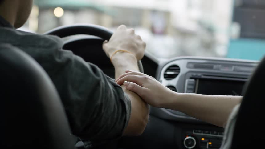 Passenger touches drivers arm as he drives