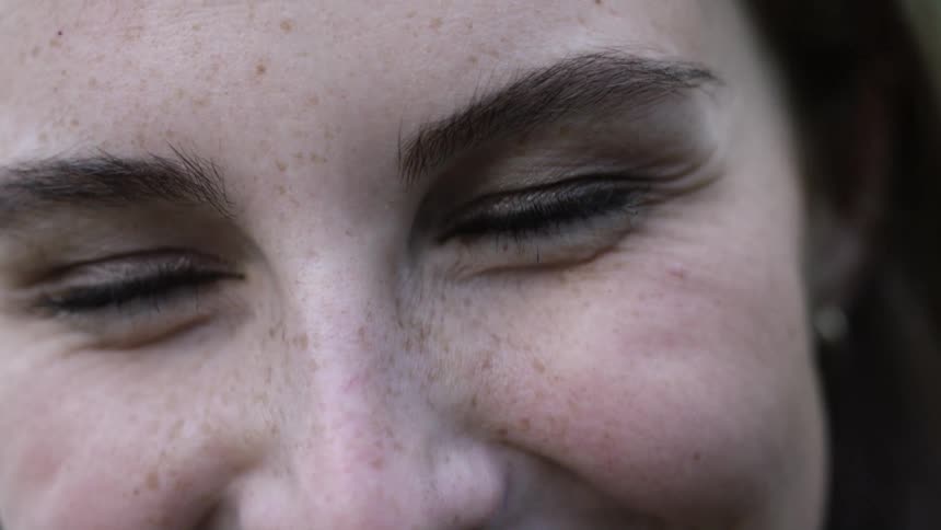 Close up of woman with freckles and dimples laughing