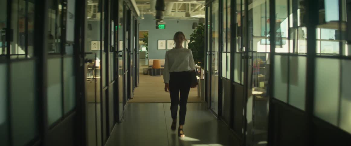 A woman walks down the hall in the office