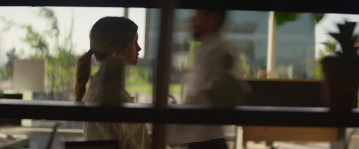A woman is walking through an office building