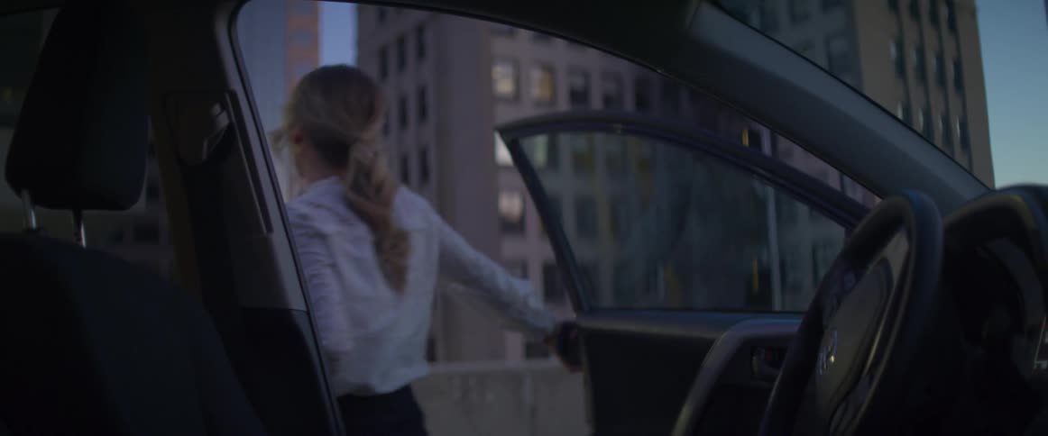 A woman gathering her belongings and exiting a vehicle