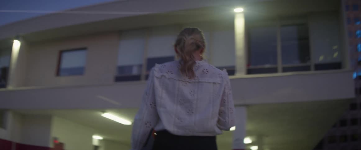 Woman leaving car and walking towards office building in early morning