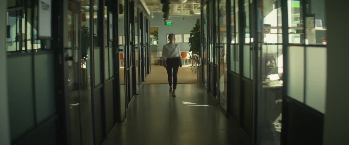 A woman walks through an office building