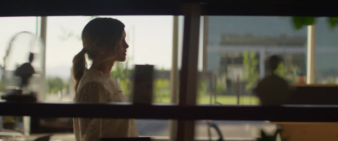 A white woman walks through an office area