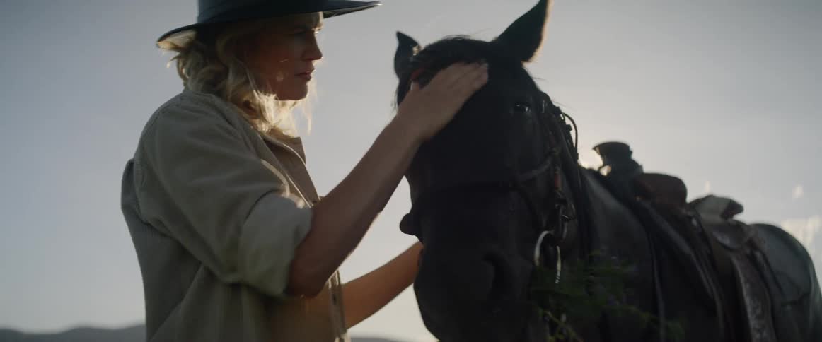 A white woman rubs a horses head